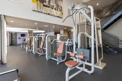 a gym with rows of exercise equipment in a building at The Heart Of Hollywood Hills in Los Angeles