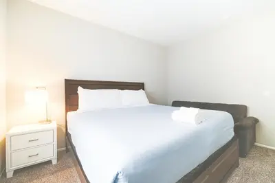 a bedroom with a large white bed and a night stand at The Heart Of Hollywood Hills in Los Angeles