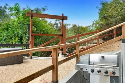 a wooden fence with a grill on a patio at Peaceful 5-Acre Stay - The Emerald Grove Retreat in La Verne
