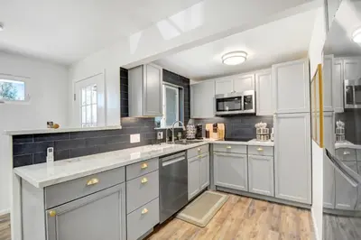 a kitchen with white cabinets and stainless steel appliances at Peaceful 5-Acre Stay - The Emerald Grove Retreat in La Verne