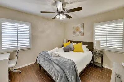 a bedroom with a bed with a ceiling fan at 4 Mi to Dtwn Riverside Gem with Pool and Game Room in Riverside