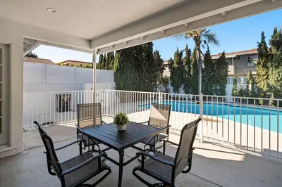 a patio with a table and chairs and a swimming pool at House with pool in prime location - 10 mins to Universal Studio in Garnsey