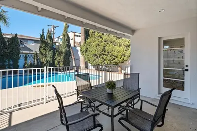 a patio with a table and chairs and a pool at House with pool in prime location - 10 mins to Universal Studio in Garnsey