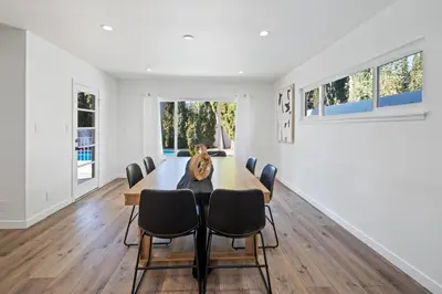 a white dining room with a table and chairs at House with pool in prime location - 10 mins to Universal Studio in Garnsey