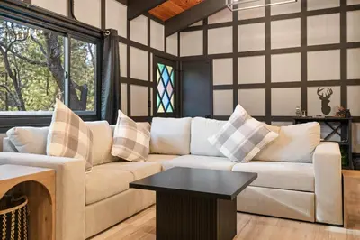 a living room with a couch and a table at Timber Wolf Tavern - Walk to Slopes, Game Room, Pool Table, BBQ in Big Bear Lake
