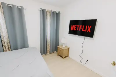 a bedroom with a netflix sign on the wall at Newly renovated, warm home with 4 bedrooms, 14 miles from Disney in Whittier