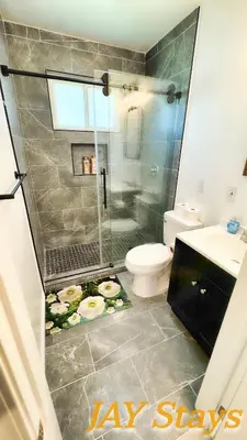 a bathroom with a shower and a toilet and a sink at Newly renovated, warm home with 4 bedrooms, 14 miles from Disney in Whittier