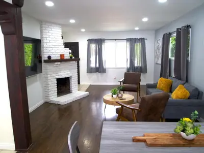 a living room with a couch and a fireplace at Cozy 3BR Home With Pool, Yard, Garage, and 80 inch TV! in Van Nuys