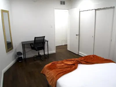 a bedroom with a bed and a desk and a computer at Cozy 3BR Home With Pool, Yard, Garage, and 80 inch TV! in Van Nuys