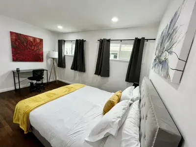 a bedroom with a large white bed and a desk at Cozy 3BR Home With Pool, Yard, Garage, and 80 inch TV! in Van Nuys