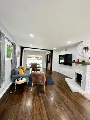 a living room with a couch and a fireplace at Cozy 3BR Home With Pool, Yard, Garage, and 80 inch TV! in Van Nuys