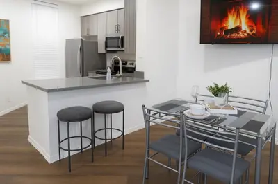 a kitchen with a counter and a table with stools at Ocean Breeze Marina Suites with Pool, Gym & Hot Tub in Los Angeles