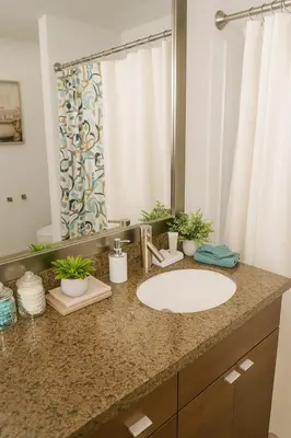 a bathroom counter with a sink and a mirror at Ocean Breeze Marina Suites with Pool, Gym & Hot Tub in Los Angeles