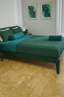 a large green bed in a room with a floor at Ocean Breeze Marina Suites with Pool, Gym & Hot Tub in Los Angeles