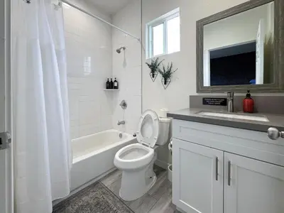 a white bathroom with a toilet and a sink at Forty First Place - Boutique Hostel in Los Angeles
