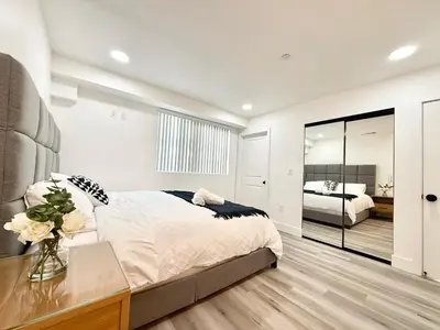 a bedroom with a large bed with a vase of flowers at GilmoreOne in Van Nuys