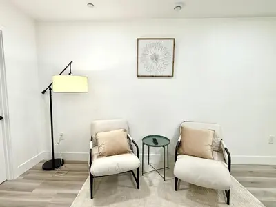 two chairs and a table in a room with white walls at GilmoreOne in Van Nuys