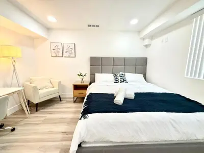 a bedroom with a large bed and a chair at GilmoreOne in Van Nuys