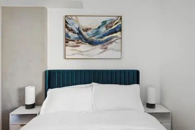 a bed with a blue headboard and two night stands at Hollywood 1bdr apt with Pool, Free Parking, Gym in Los Angeles