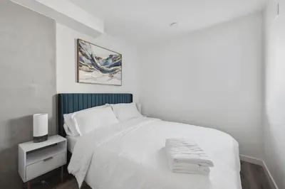 a bedroom with a white bed with a green headboard at Hollywood 1bdr apt with Pool, Free Parking, Gym in Los Angeles