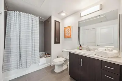 a white bathroom with a toilet and a sink at Spacious 1BDR near Walk of Fame with Luxury Amenities in Los Angeles