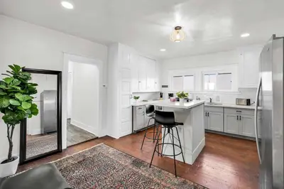 a white kitchen with a counter and a mirror at Charming Craftsman Near DTLA in Los Angeles