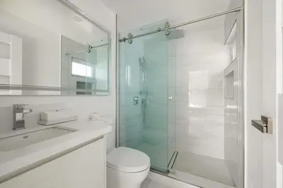 a bathroom with a shower and a toilet and a sink at Pacific Coast Suites - Oceanfront Living in Los Angeles