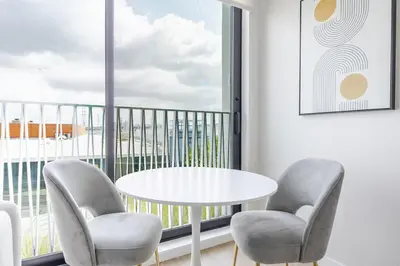 a table and chairs in a room with a balcony at Blueground Downtown elevator nr parks LAX-1252 in Los Angeles