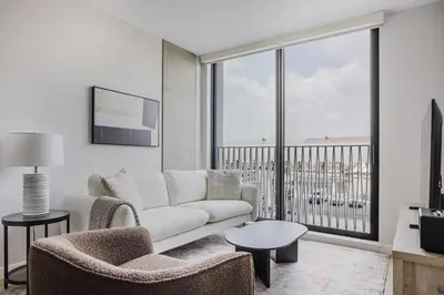 a living room with a couch and chairs and a large window at Blueground Downtown AC elevator nr parks LAX-1253 in Los Angeles