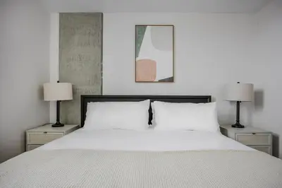 a bedroom with a white bed with two lamps at Blueground Downtown AC elevator nr parks LAX-1253 in Los Angeles