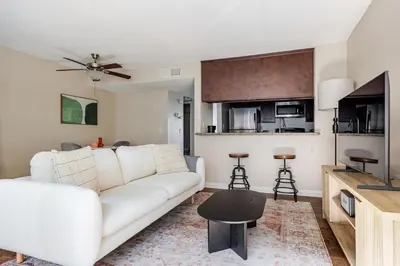 a living room with a white couch and a kitchen at Blueground Glendale pool AC nr Americana LAX-1319 in Glendale