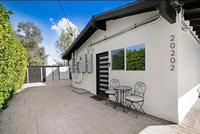 a patio with two chairs and a table in front of a building at Wellness Temple LA in Tarzana
