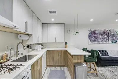 a kitchen with white cabinets and a sink and a couch at Wellness Temple LA in Tarzana