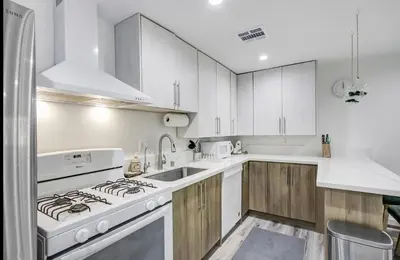 a kitchen with white cabinets and a stove top oven at Wellness Temple LA in Tarzana