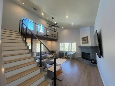 a living room with a staircase and a fireplace at Rancho del Cielo in Twin Lakes