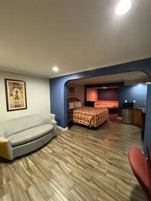 a hotel room with a bed and a couch at Sunset Inn & Suites in Gardena