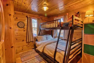 a bedroom with a bunk bed in a log cabin at Ray's Dear Cottage in Wrightwood