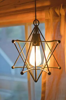 a metal light fixture hanging from a window at Ray's Dear Cottage in Wrightwood