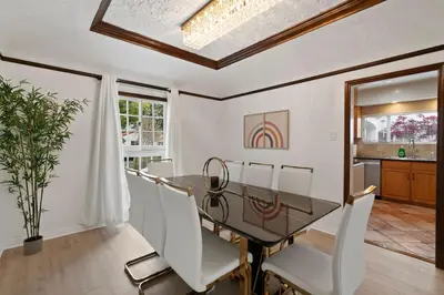 a dining room with a glass table and white chairs at Spacious 4BR House with Large Yard and Parking Beverly Hills Adj in Los Angeles