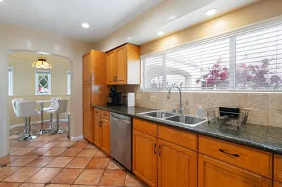 a kitchen with wooden cabinets and a sink and a window at Spacious 4BR House with Large Yard and Parking Beverly Hills Adj in Los Angeles