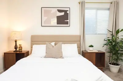 a bedroom with a white bed with two night stands at Central Modern All-In-One Home in Lakewood