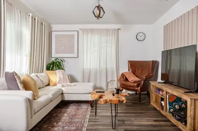 a living room with a white couch and a flat screen tv at Central Modern All-In-One Home in Lakewood