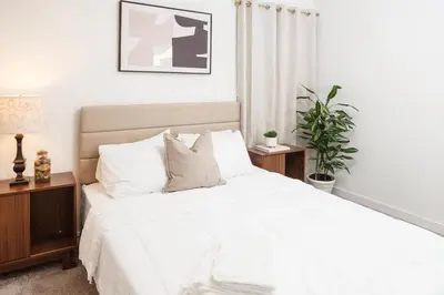 a bedroom with a large white bed with a plant at Central Modern All-In-One Home in Lakewood