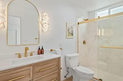 a bathroom with a shower and a toilet and a sink at Seaside and Newly Renovated in Summerland