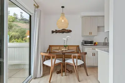 a small kitchen with a table and chairs and a window at Seaside and Newly Renovated in Summerland