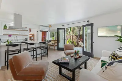 a living room with a couch and a table at Private Garden and Family Friendly in Summerland