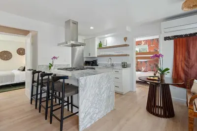 a kitchen with a counter and a kitchen island with bar stools at Private Garden and Family Friendly in Summerland