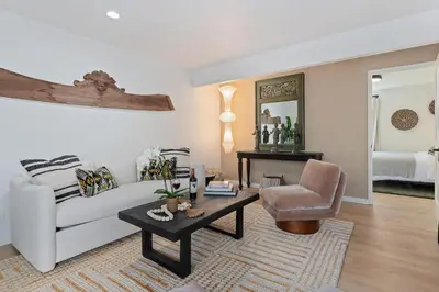 a living room with a white couch and a chair at Private Garden and Family Friendly in Summerland