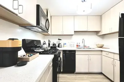 a kitchen with white cabinets and black appliances at Serenity Retreat in Santa Monica in Los Angeles