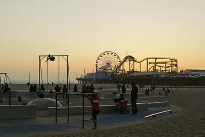 a group of people on the beach with a roller coaster at Serenity Retreat in Santa Monica in Los Angeles